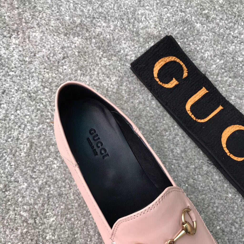 Pink Gucci loafer upper detail with gold-tone bit hardware and black interior