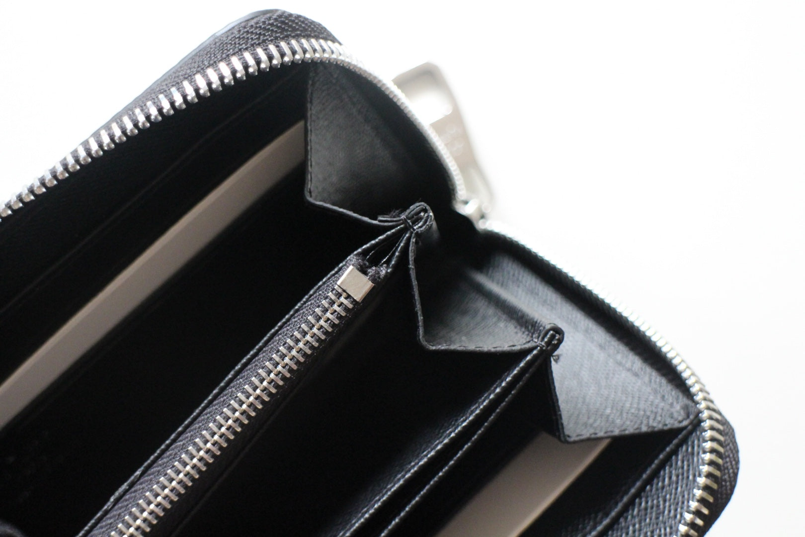 Small Louis Vuitton zip wallet open interior with zip track and compartment pockets.