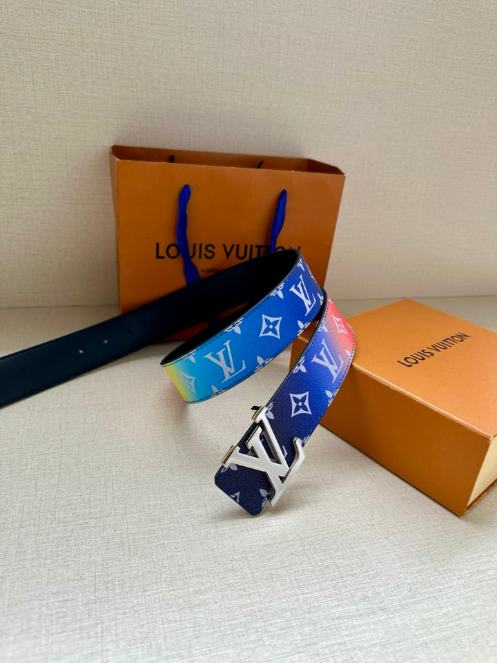 Blue monogram belt with gold-tone buckle, resting on orange gift boxes