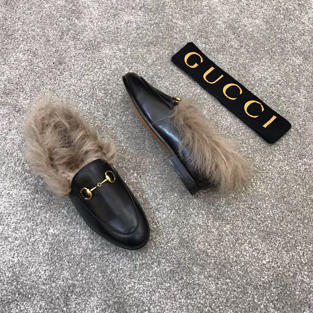 Gucci black slip-on loafers with faux fur trim and gold bit hardware, pair view