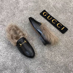 Gucci black slip-on loafers with faux fur trim and gold bit hardware, pair view