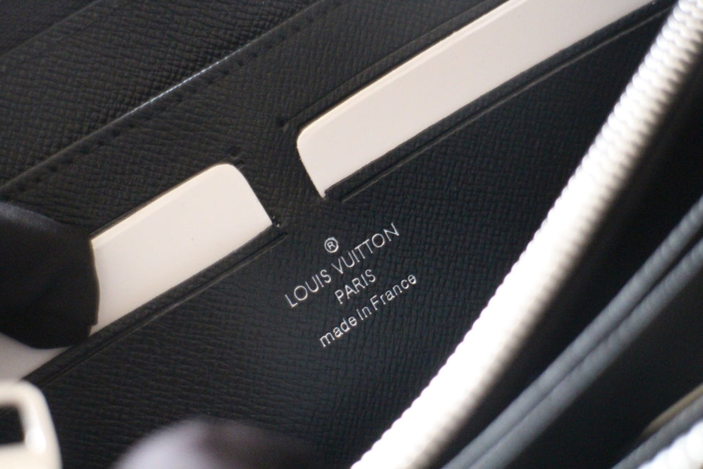Small Louis Vuitton zip wallet interior with brand stamp and “made in France” text.