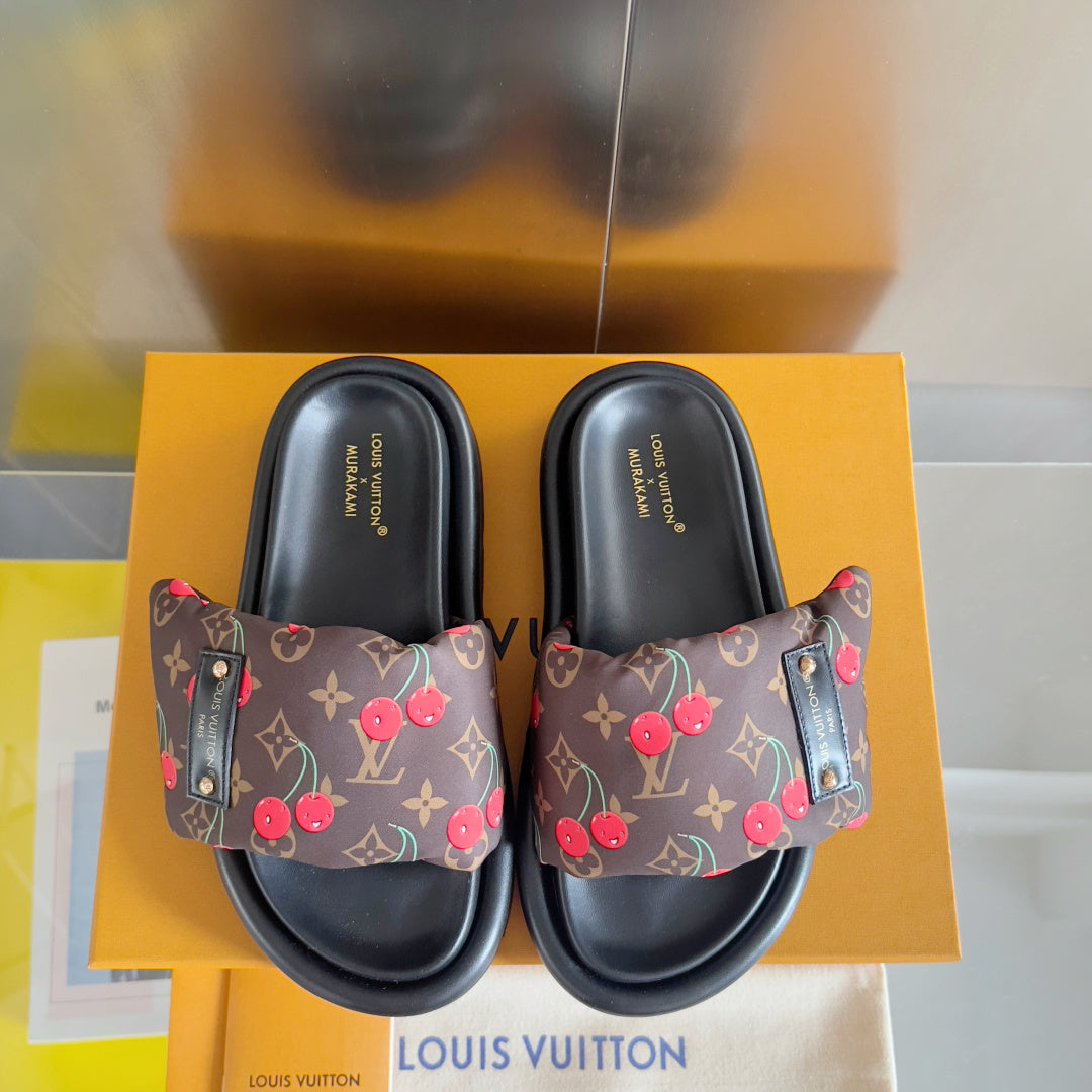 Louis Vuitton slide sandals showing dark monogram straps with red cherry print and black base