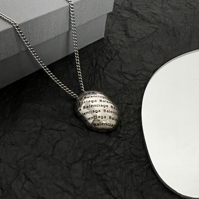 Round logo pendant necklace with layered silver-tone chain