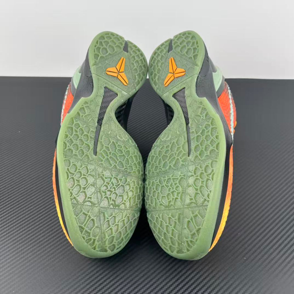 Basketball shoe outsole and heel with green traction pattern and orange accents