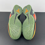 Basketball shoe outsole and heel with green traction pattern and orange accents