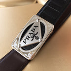 Prada belt buckle on dark leather strap with silver frame and PRADA logo