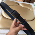 Navy leather belt with textured strap and metal buckle, punched holes detail.