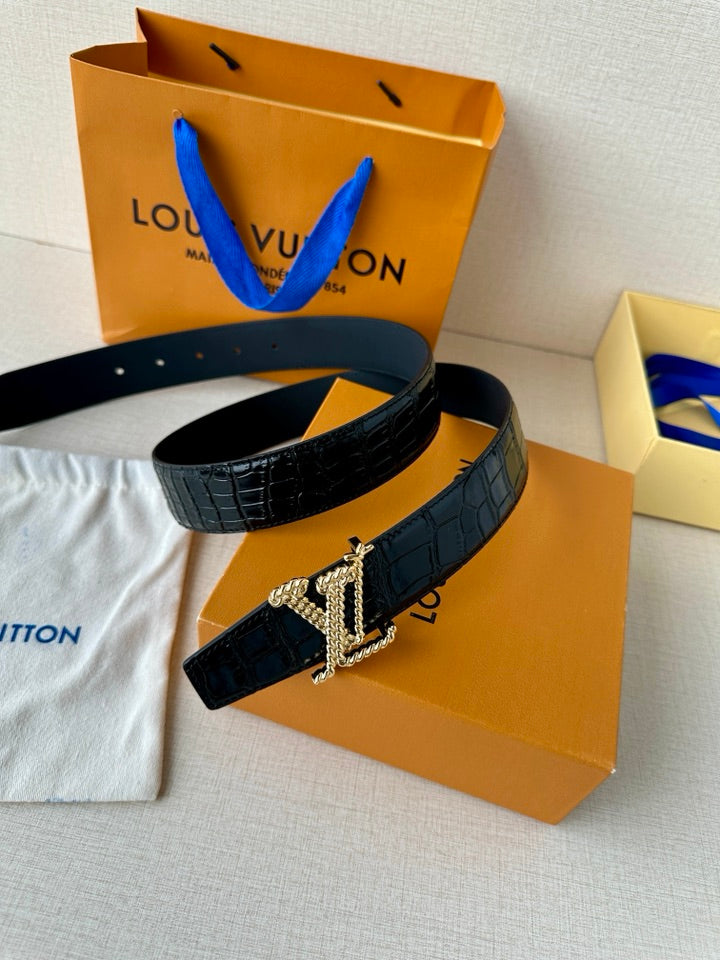 Dark blue croc leather belt with gold-tone LV buckle on a fabric surface