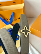 Louis Vuitton belt with star buckle on gray strap; dark blue reversible side