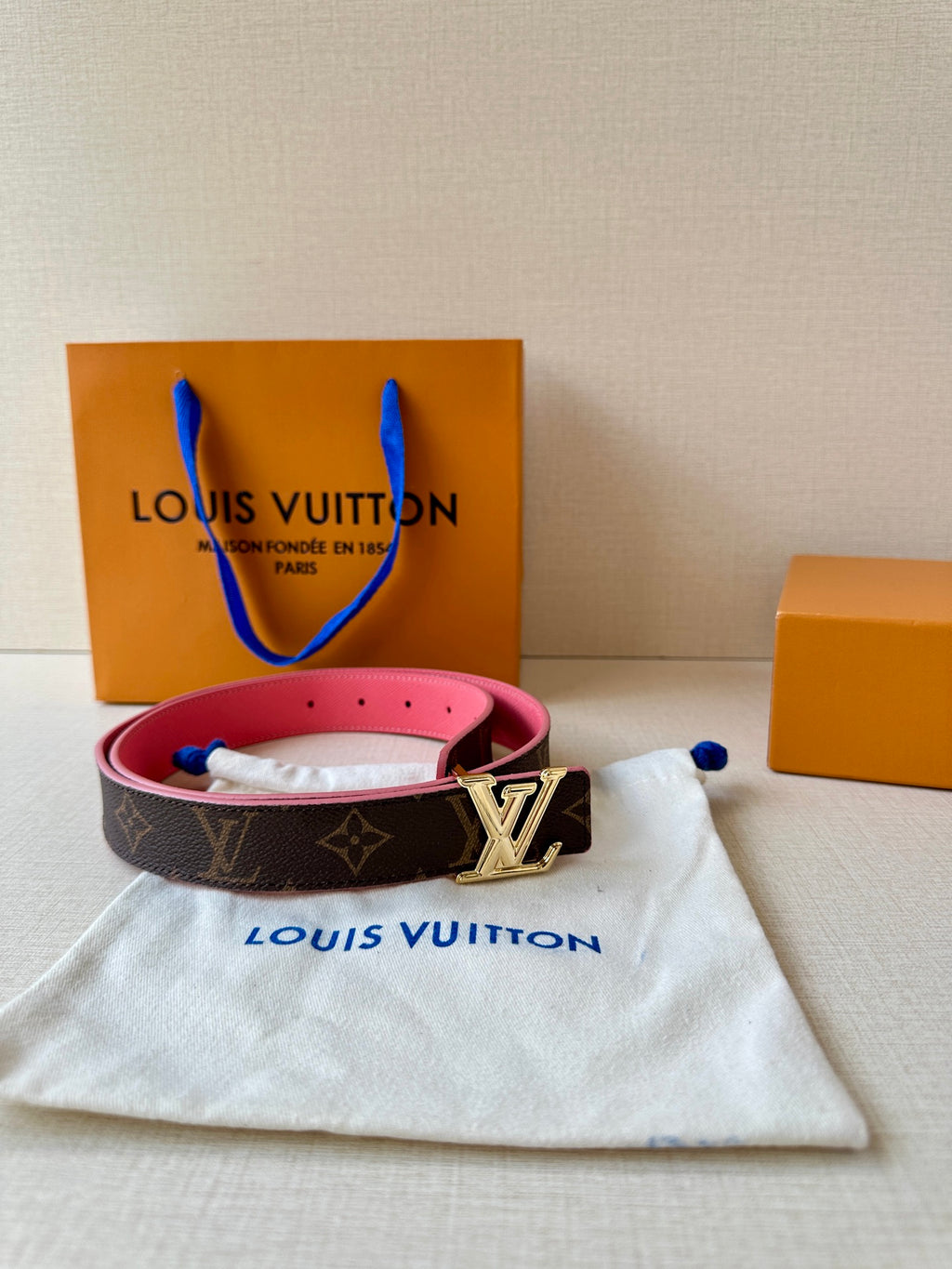 Dark monogram belt with silver LV buckle and pink strap, with dust bag