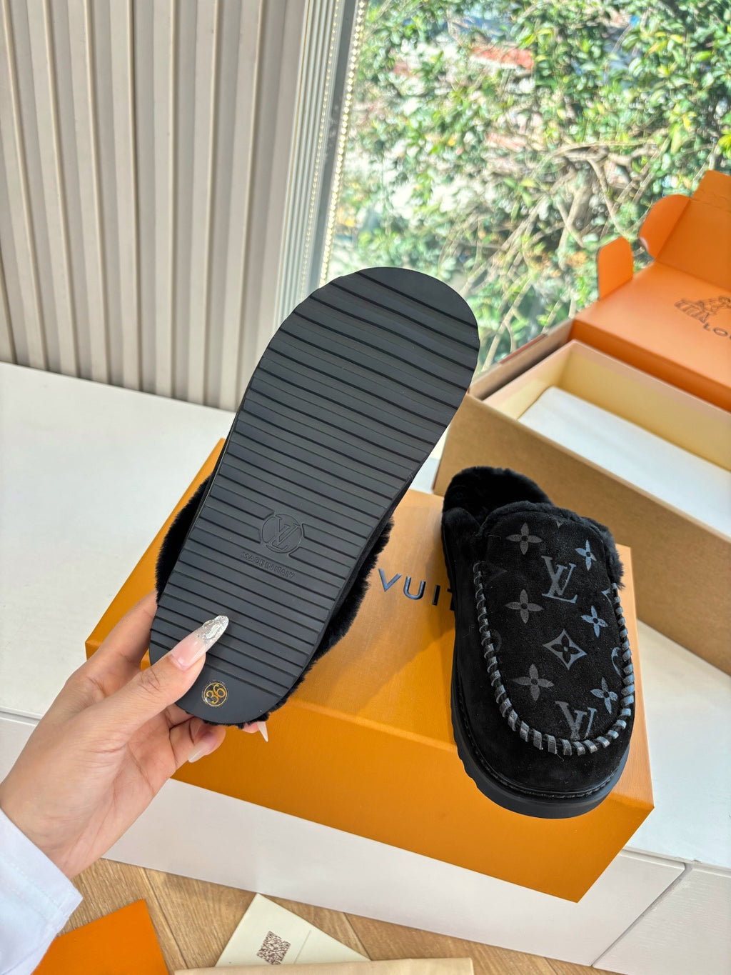Black Louis Vuitton monogram slipper with tread sole shown, plush upper