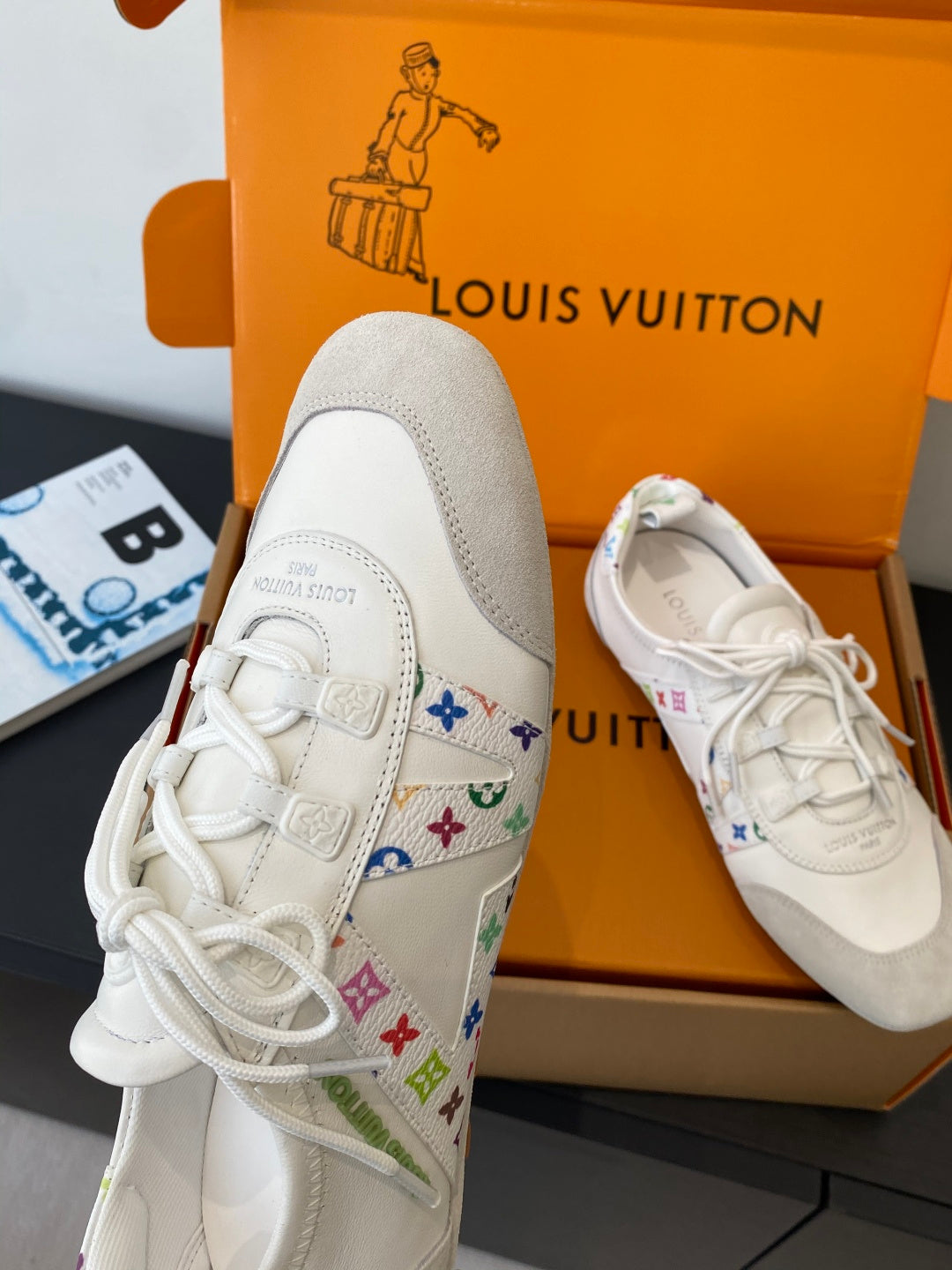 White unisex sneakers with multicolor logo detail along the side and white laces