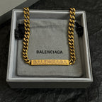 Balenciaga gold-tone chain necklace in a box on gray fabric cushion