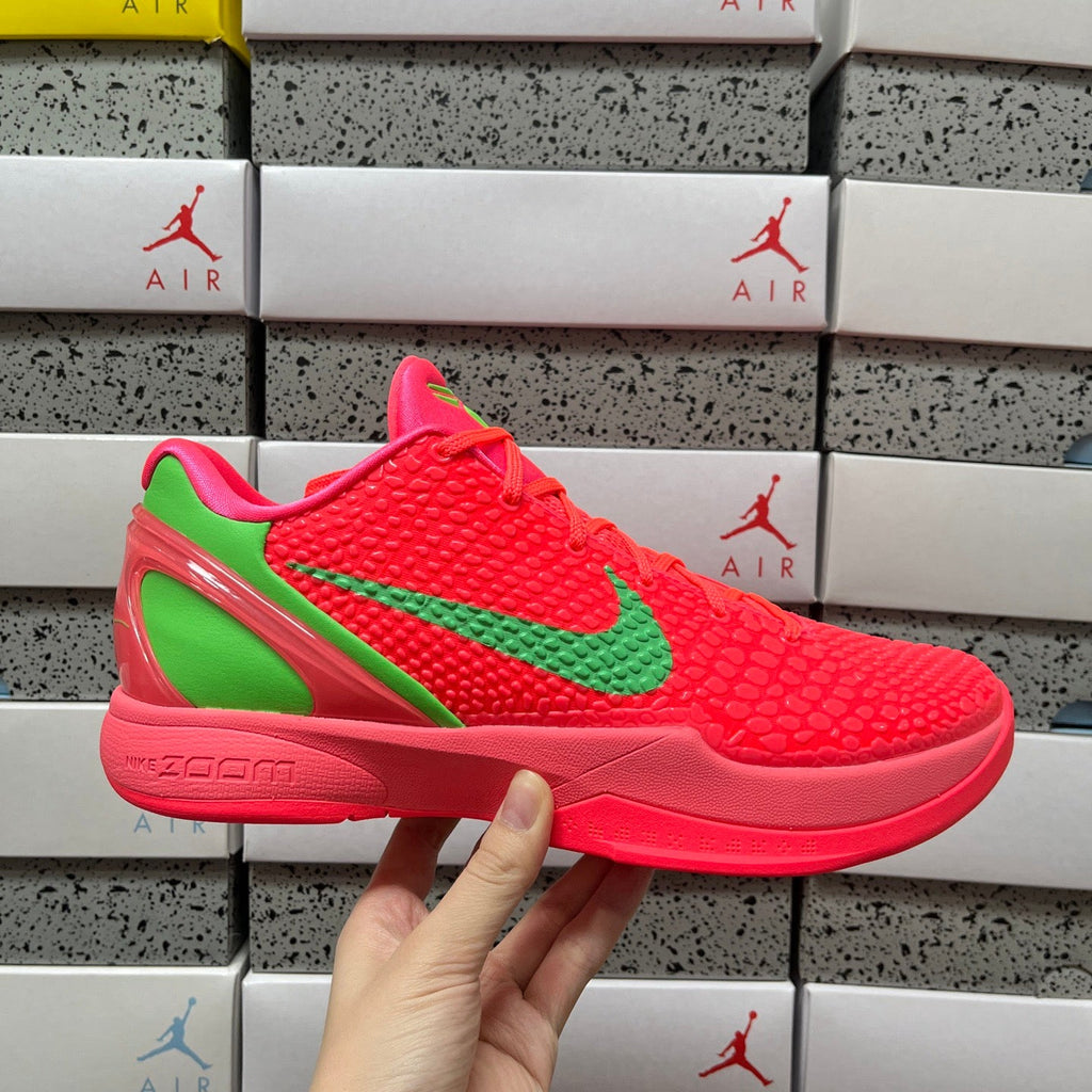 Red low-top sneaker with green swoosh and textured upper, lace-up