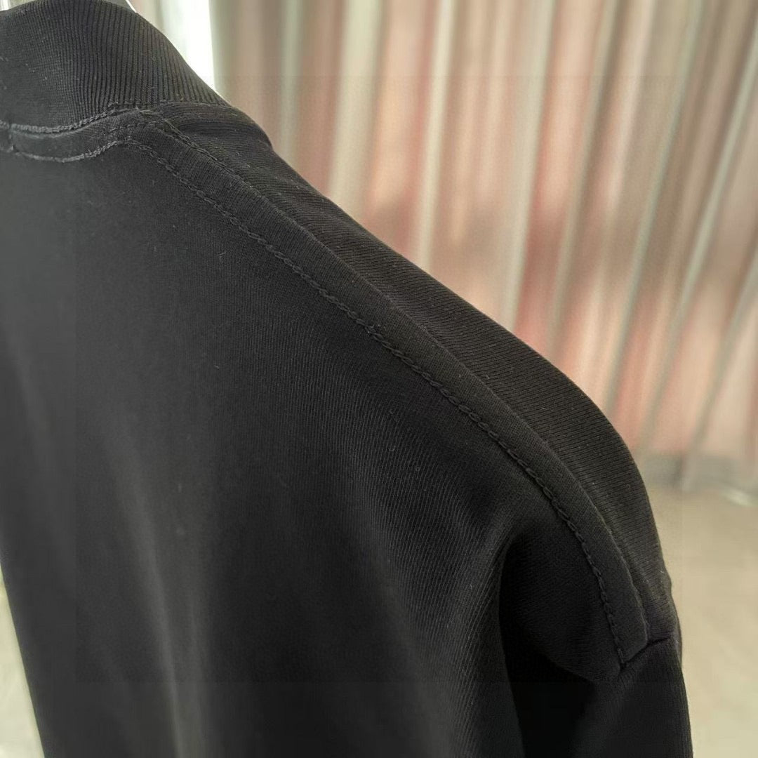 Black T-shirt fabric close-up with stitched seam and textured knit