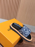 Louis Vuitton slide sandals in blue monogram-pattern fabric with black footbed, tan sole