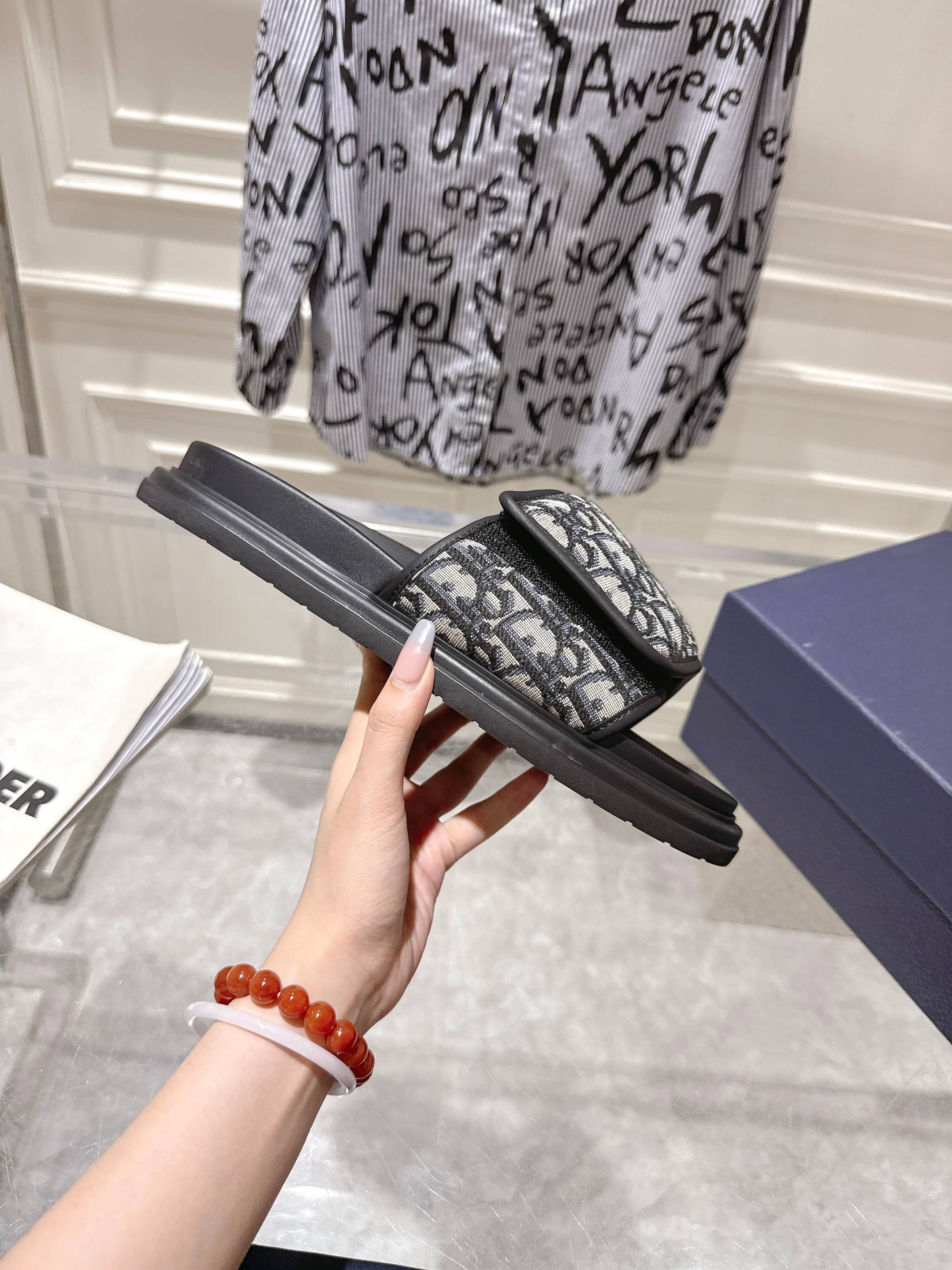 Dior slide sandal showing side view; gray Dior-oblique strap on black platform sole