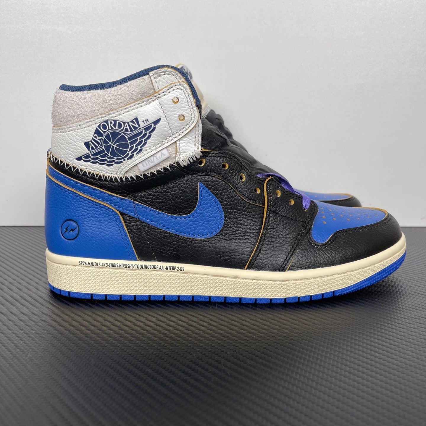 High-top sneakers with black leather, blue overlays and swoosh, white heel collar, lace accents