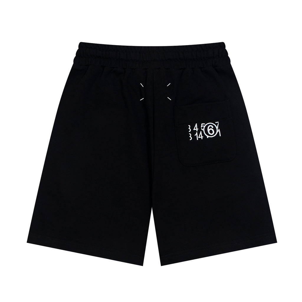 Black Maison Margiela shorts with drawstring and logo graphic on front pocket.