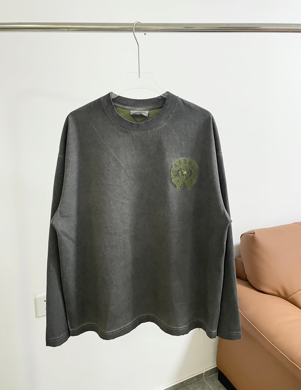 Dark gray long-sleeve T-shirt with crew neck and small green chest logo.