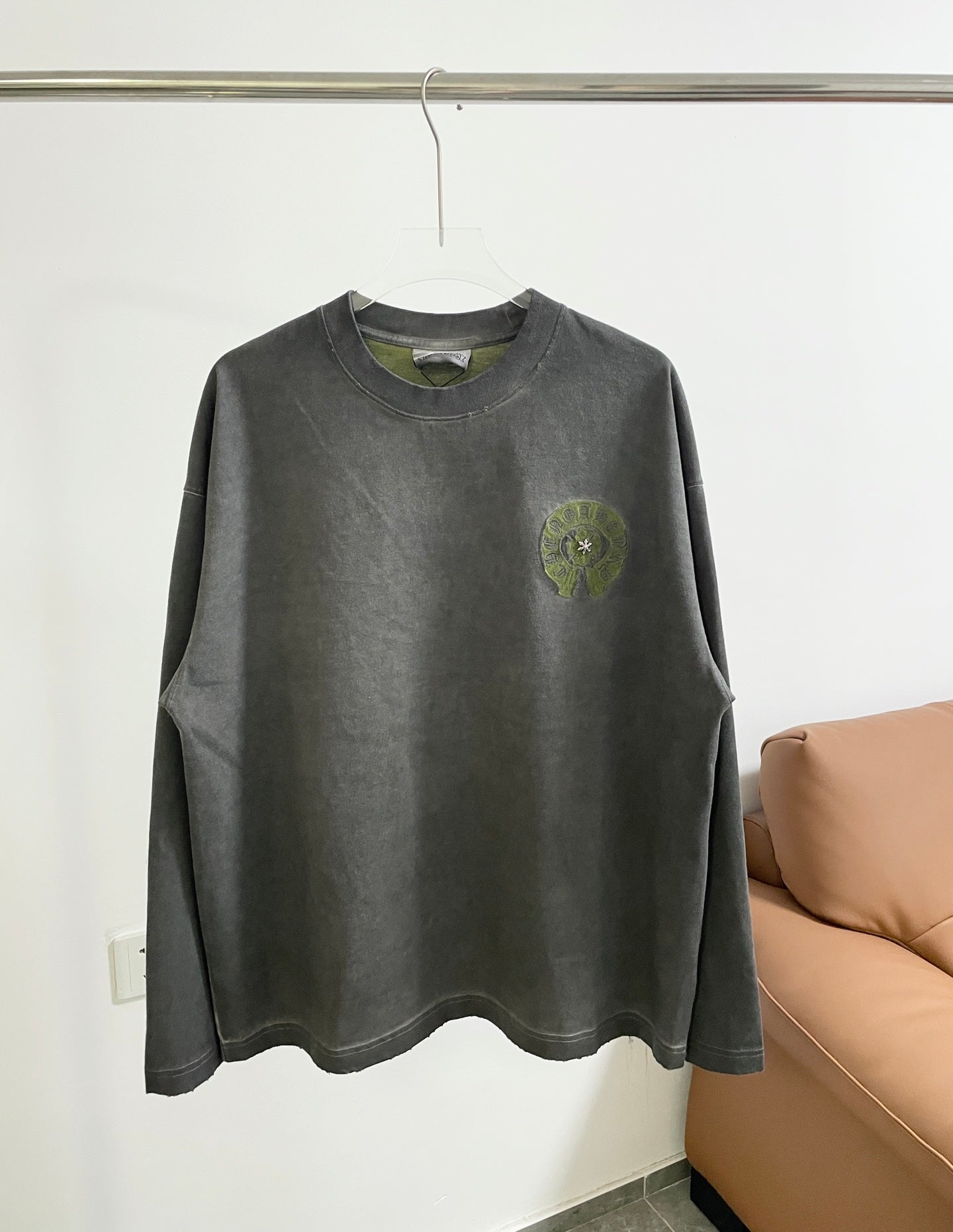 Dark gray long-sleeve T-shirt with crew neck and small green chest logo.