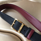 Prada belt on light upholstery, dark strap with gold buckle and burgundy trim