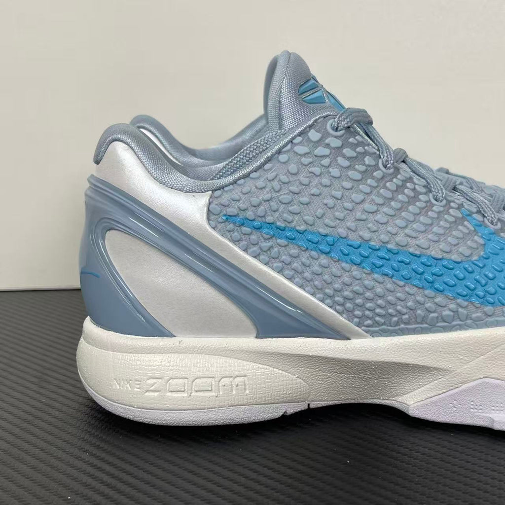 Light blue and gray basketball shoes with blue swoosh, padded collar, white midsole.