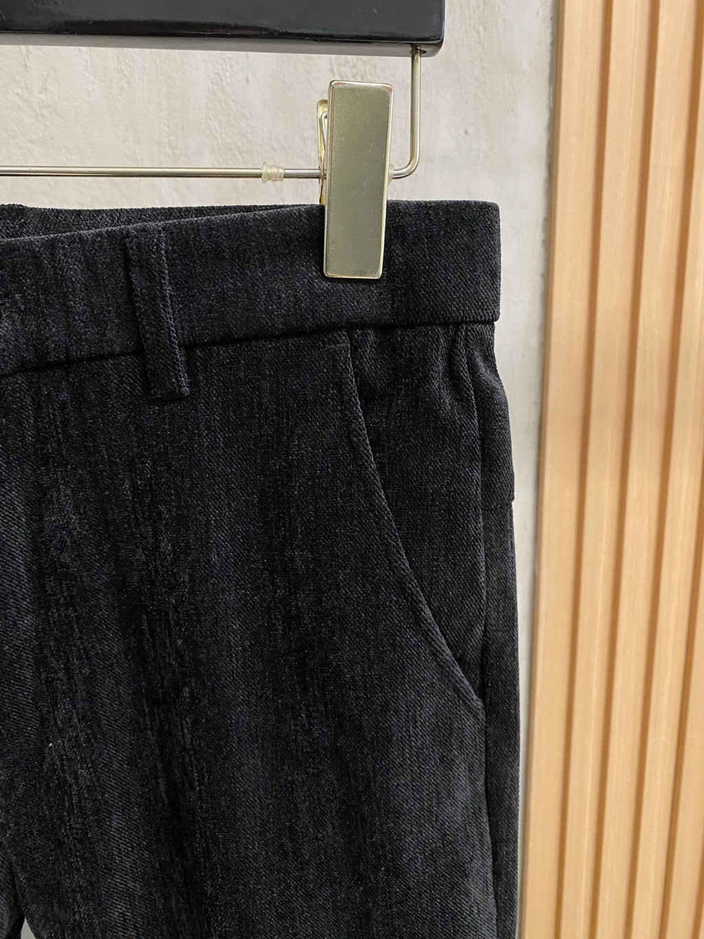 Black trousers with pleated waistband and front belt loops