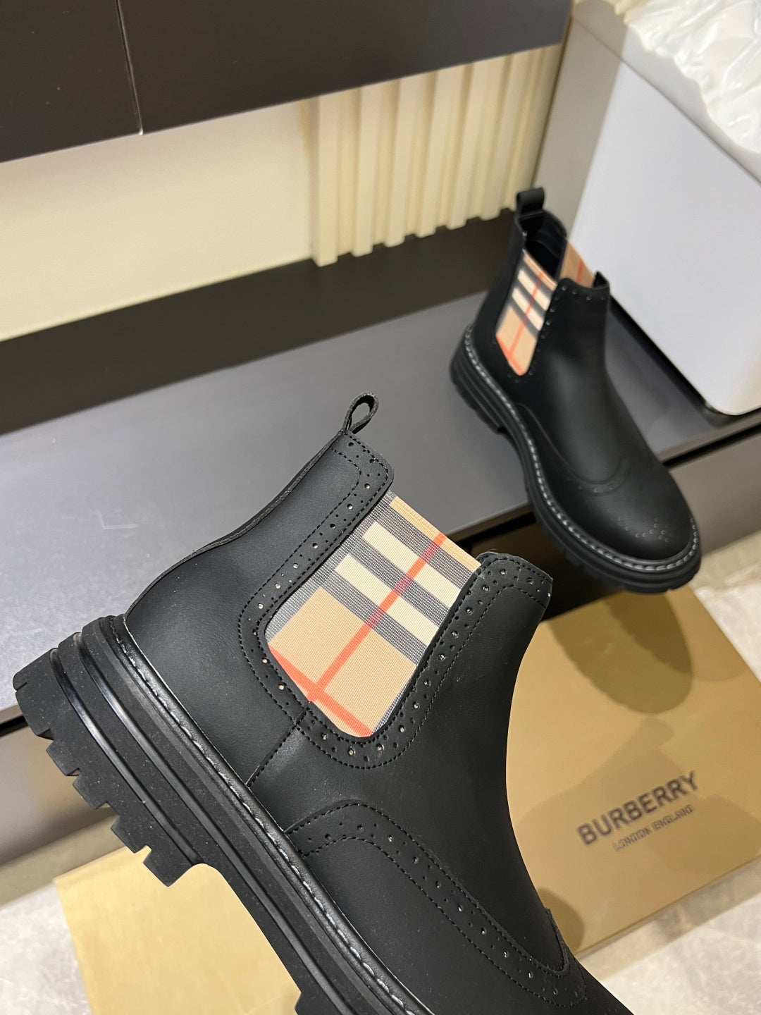 Black leather Chelsea boots with check-panel side gore and chunky tread sole