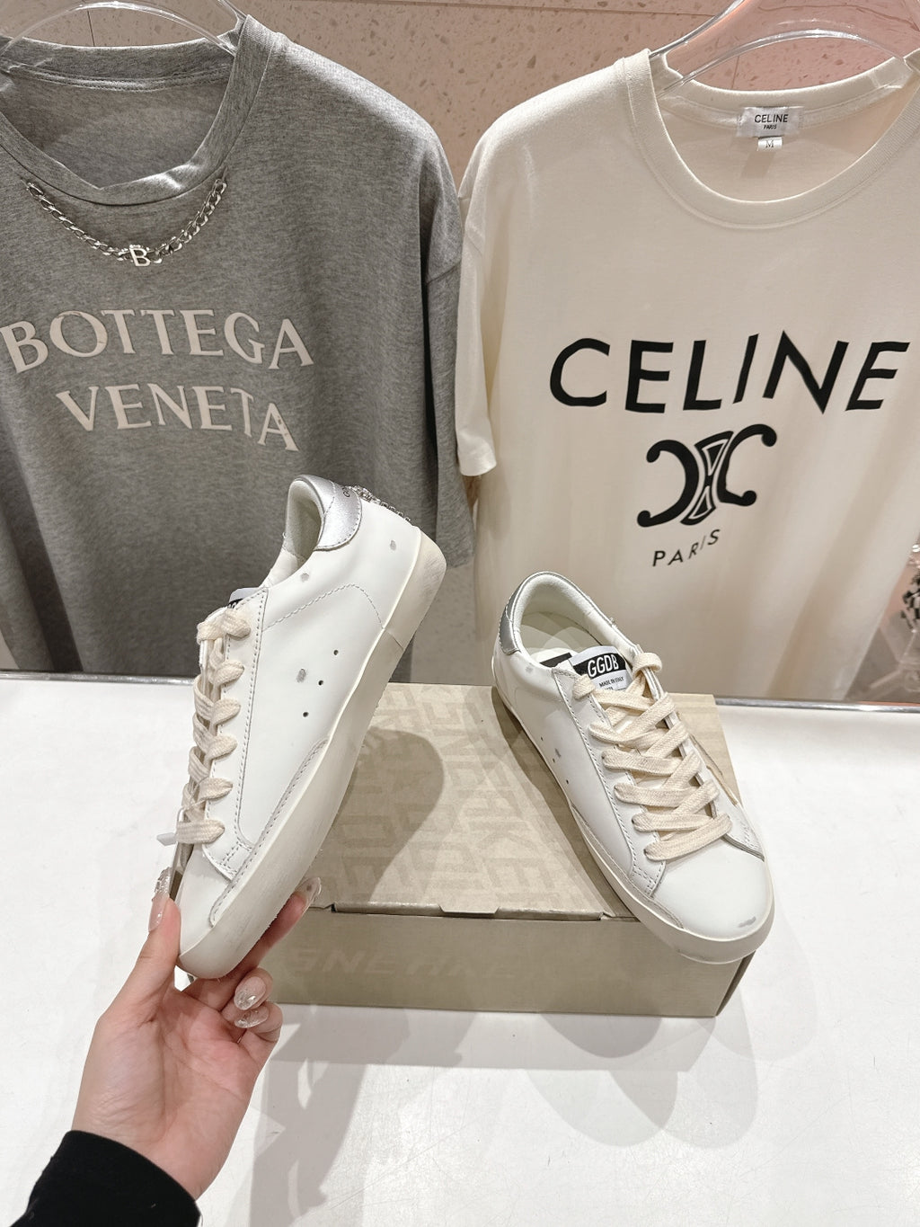 White Golden Goose low-top sneakers with lace-up closure, held shoe view