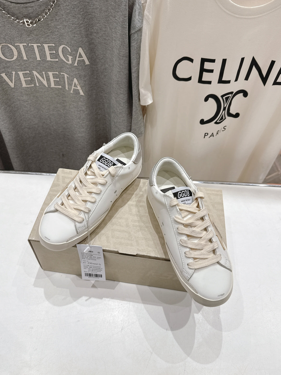 White lace-up Golden Goose sneakers, angled side view on box