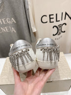 Pair of white Golden Goose slip-on shoes with silver fringe strap detail