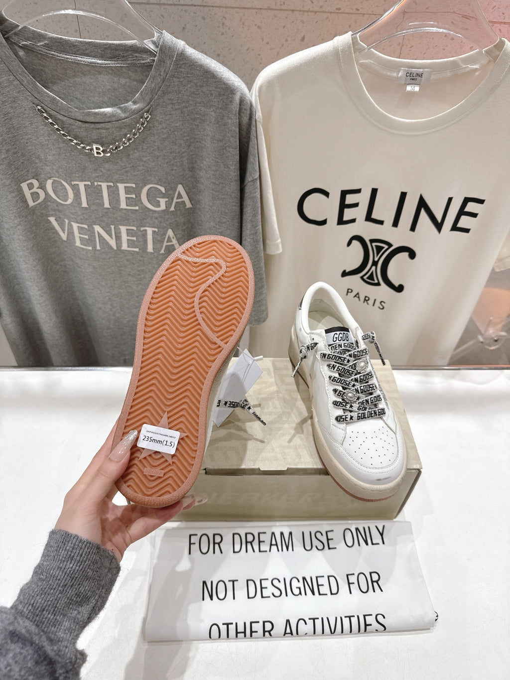 White low-top sneakers with black graphic laces and gum rubber outsole
