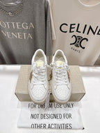 White lace-up sneakers with perforated toe and cushioned sole, front view