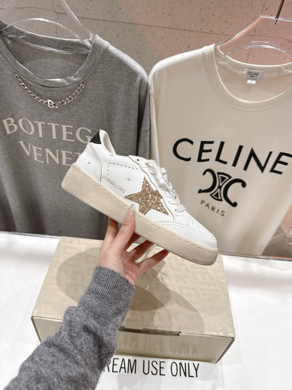 White lace-up sneakers with gold star patch, side view