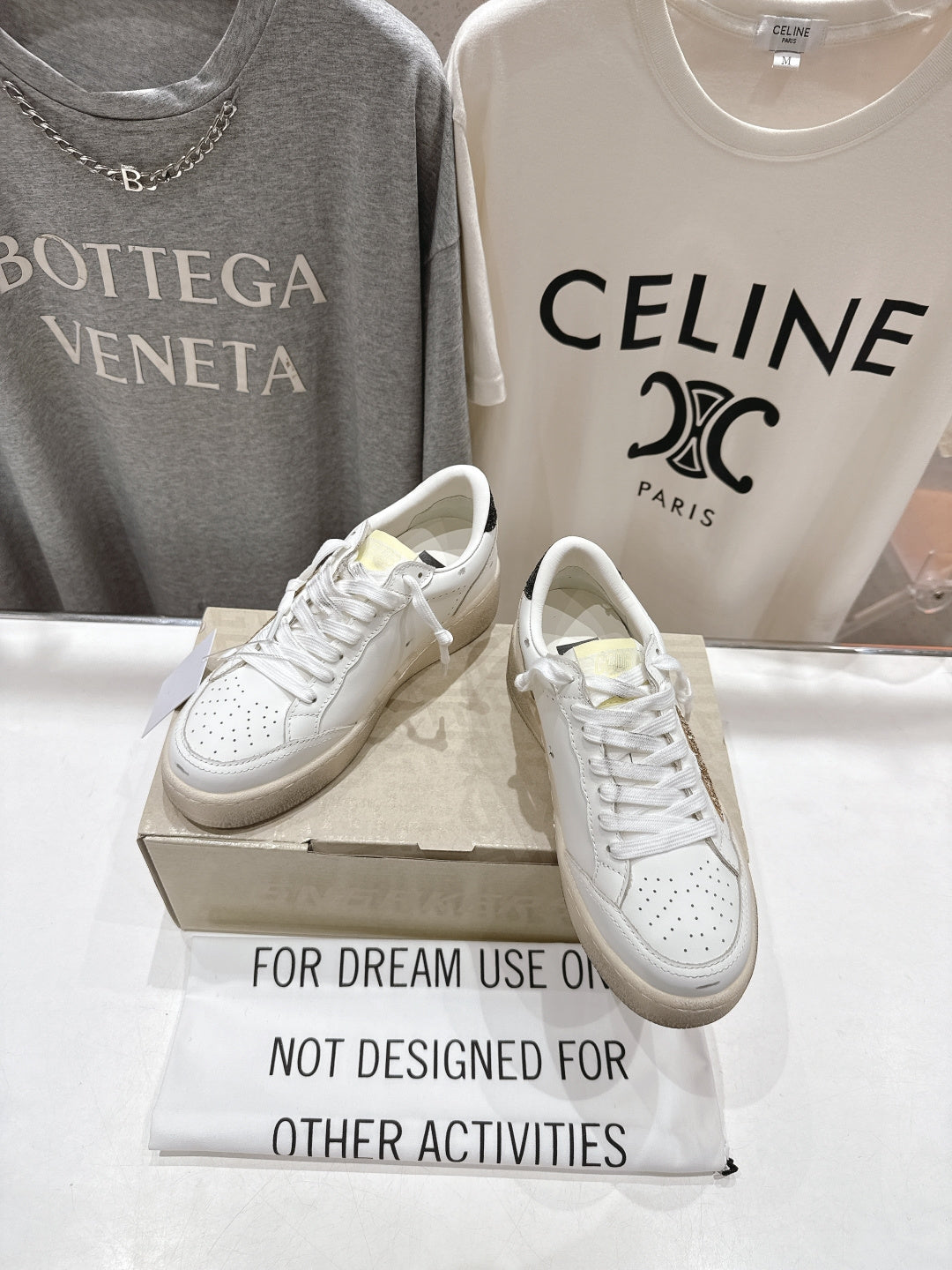 White lace-up sneakers on a box, side view with perforated toe