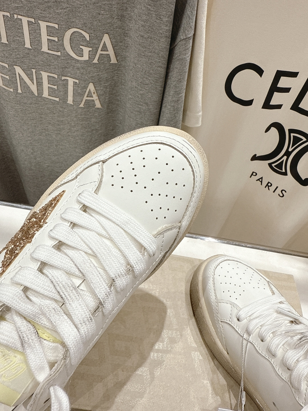 Close-up of white sneakers with perforated toe and lace-up front