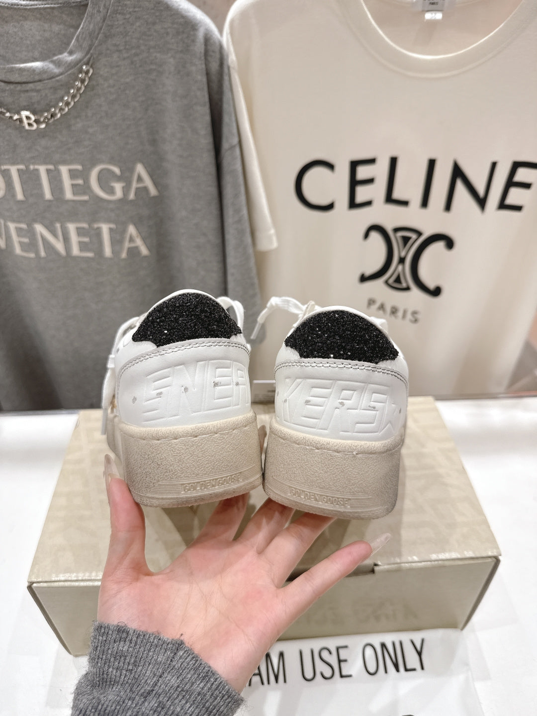 White sneakers with dark heel panels and textured rubber sole, back view