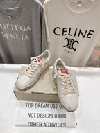 White lace-up low-top sneakers with red heel tab detail on display box