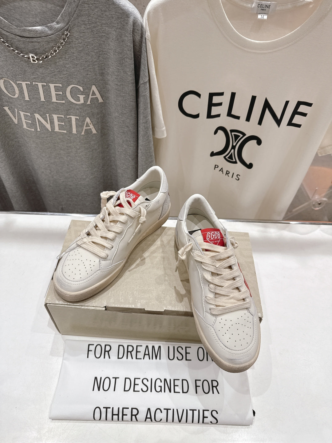 White lace-up low-top sneakers with red heel tab detail on display box