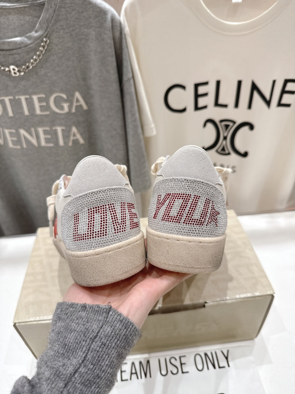 Back view of white lace-up low-top sneakers with red-printed heel panels