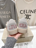 Back view of white lace-up low-top sneakers with red-printed heel panels