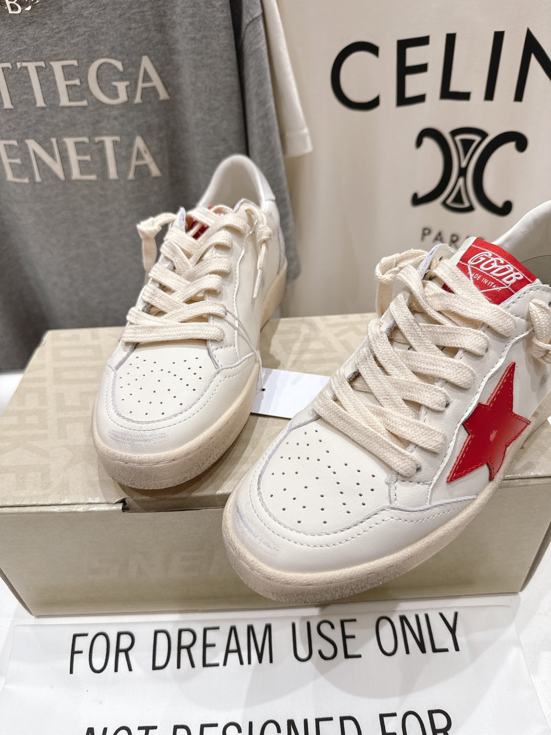 Front view of white lace-up low-top sneakers with red star patch and perforated toe