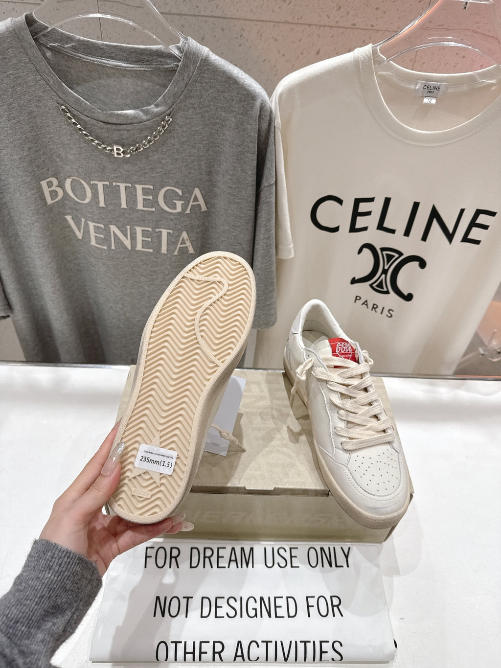 Beige textured outsole of a white lace-up low-top sneaker, shown in hand