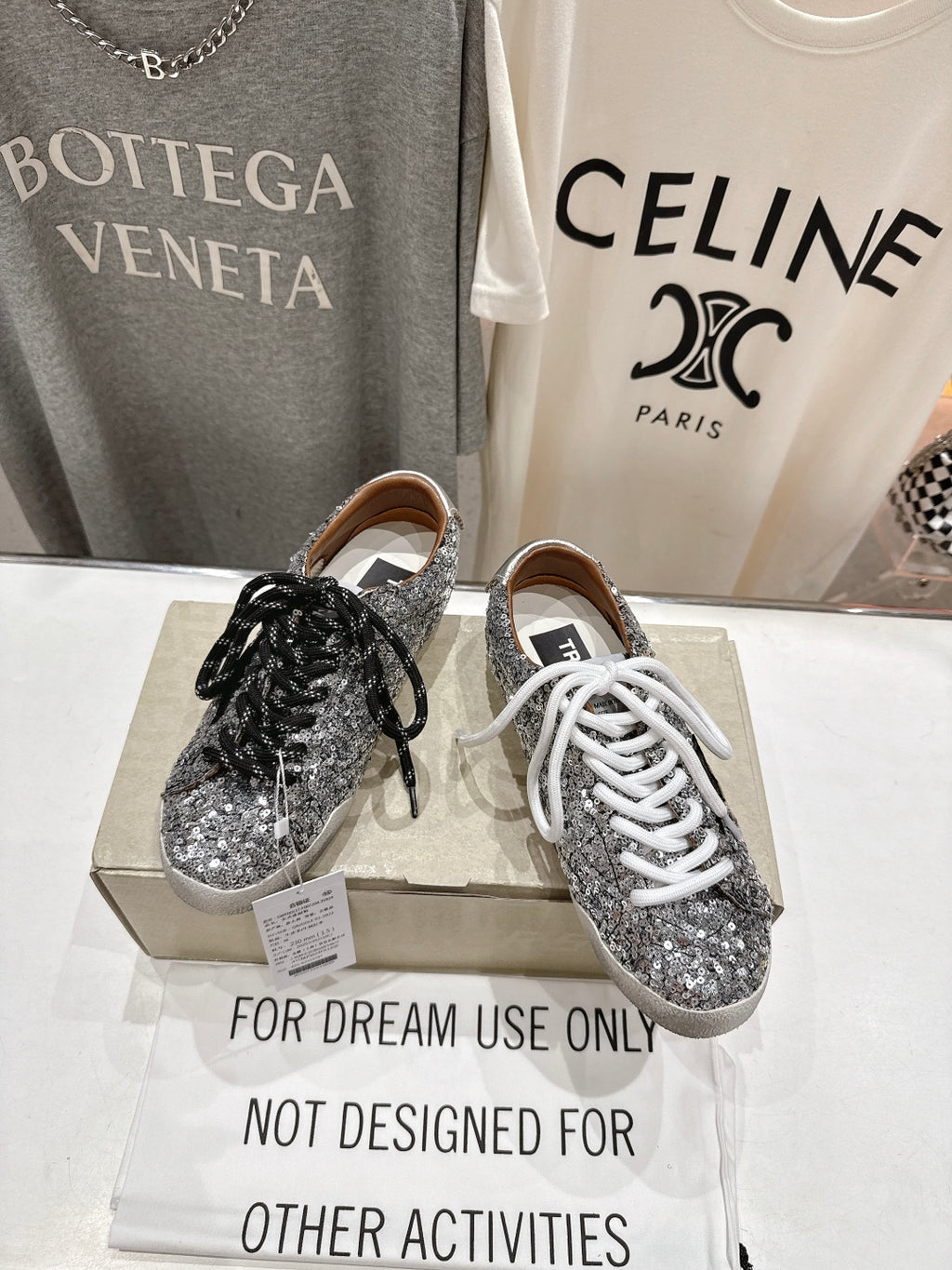 Pair of silver sequin sneakers on box, black and white lace styles