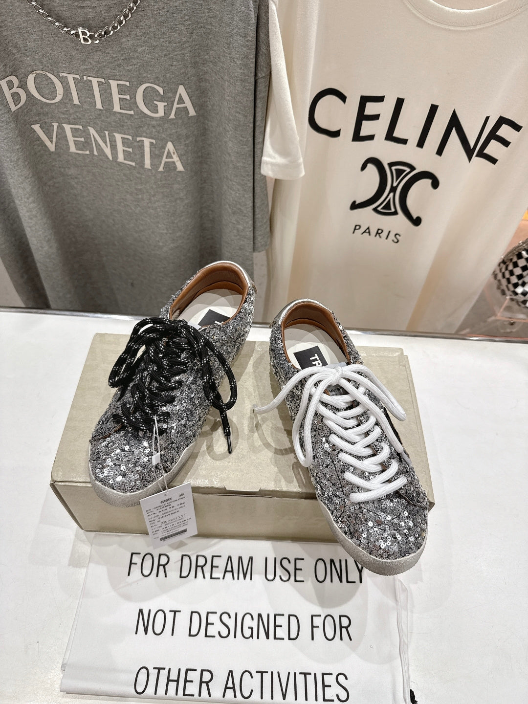 Pair of silver sequin sneakers on box, black and white lace styles
