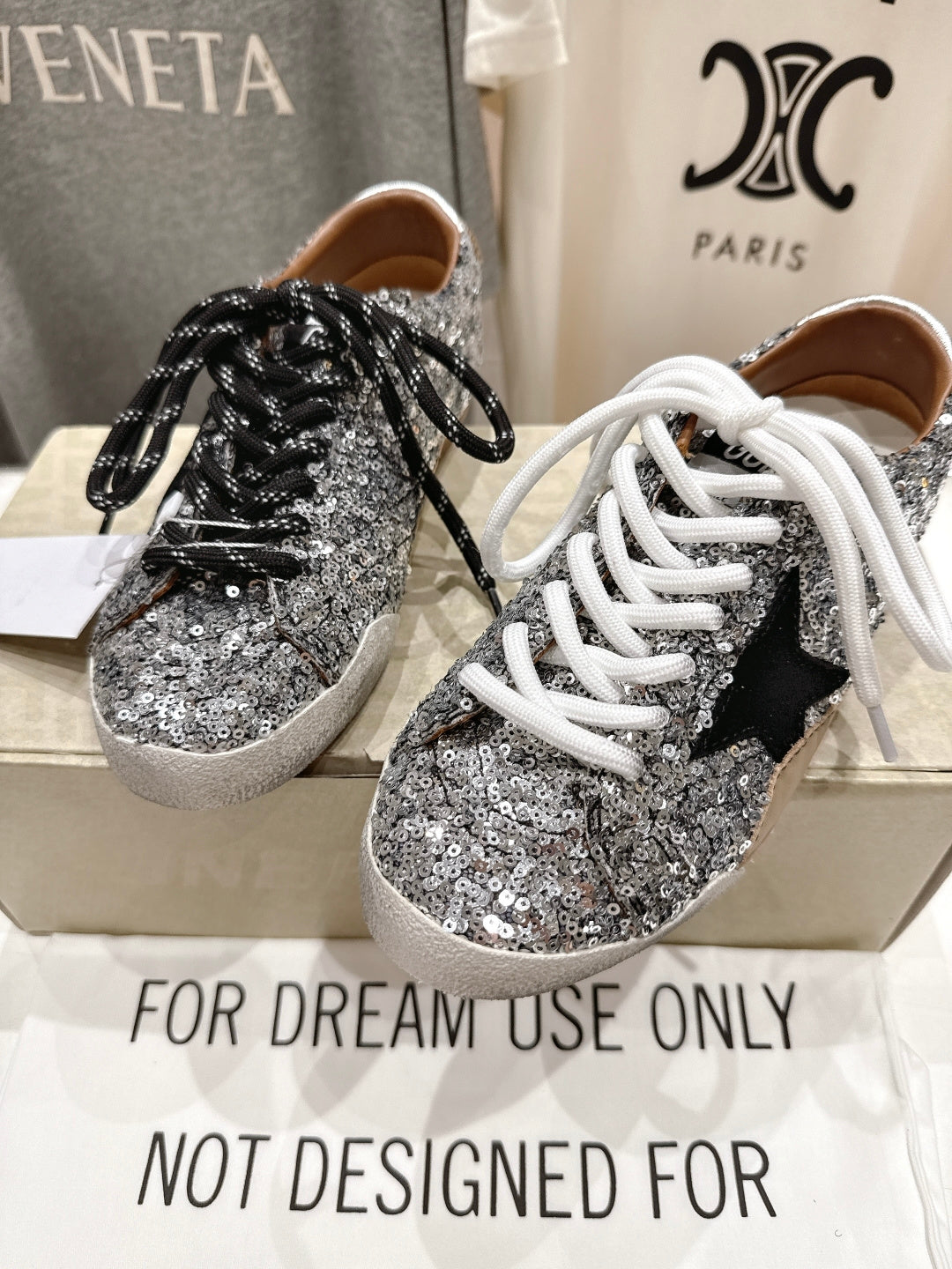 Pair of silver sequin sneakers with black and white laces, front view