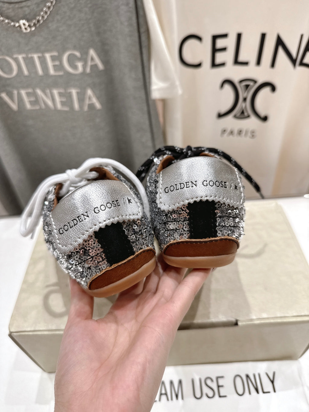 Back view of Golden Goose sneakers: silver sequin heels, black and white laces