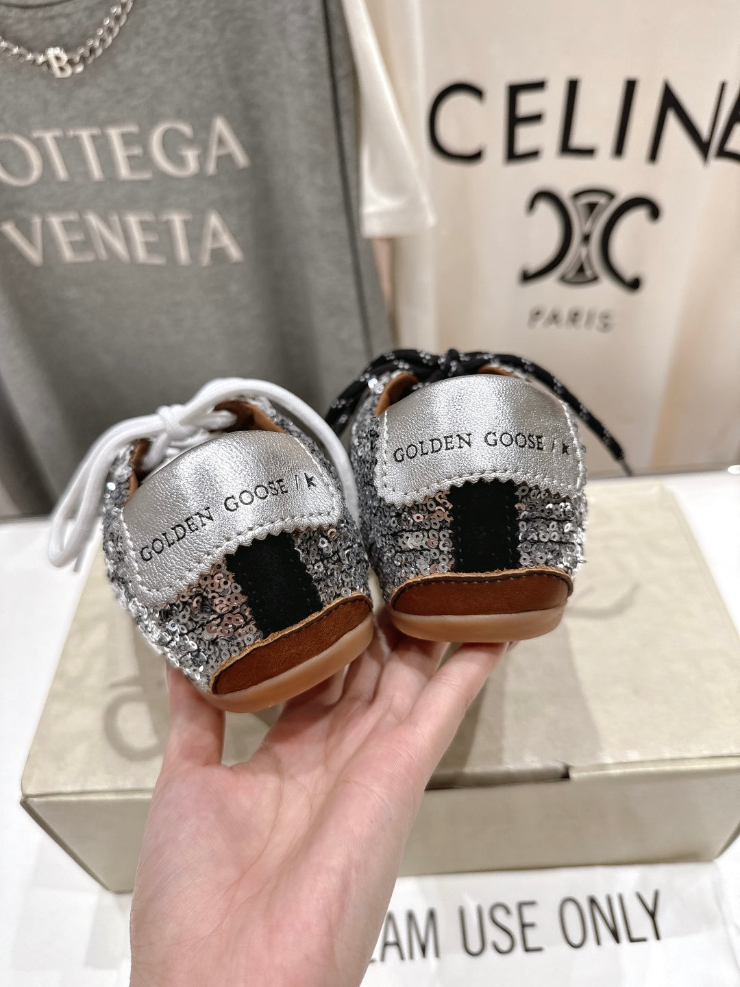 Back view of Golden Goose sneakers: silver sequin heels, black and white laces